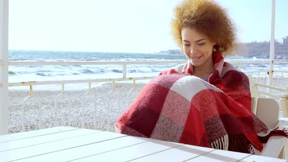 Beautiful Pensive Redhead Woman Sitting at the Beach Watching the Sea