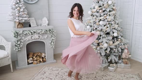 Beautiful Girl Woman Near Christmas Tree Smiling Dancing in Beautiful Dress in Decorated House