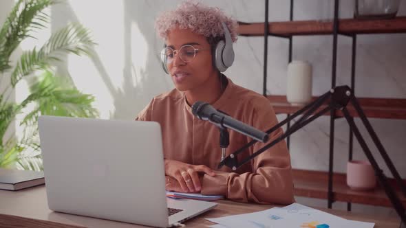 Black Woman with Blond Curly Hair Puts on Headphones and Starts Her Radio Show