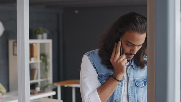 Young Businessman Talking on Phone in Office