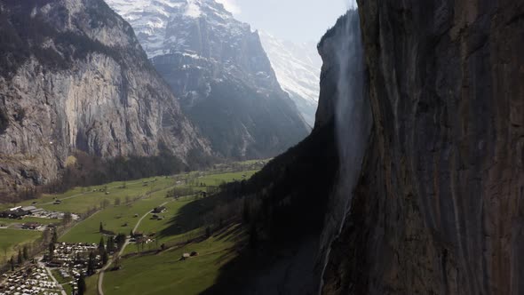 Aerial flying sidewards showing Lauterbrunnen and the waterfall on a sunny day, Switzerland
