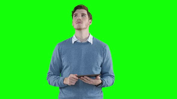 Caucasian man using a digital tablet on green background