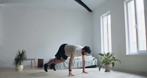 Young Man Practicing Burpee Exercise at Home