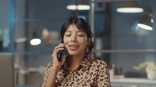 Hispanic Businesswoman Talking on Phone Late in Office