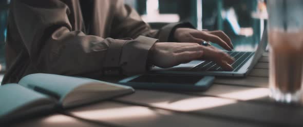 Young business woman typing and working on a laptop while looking up