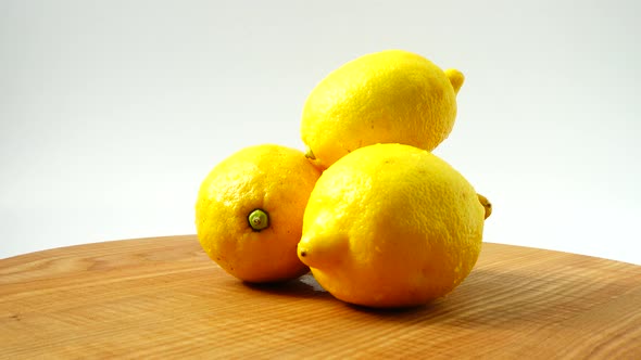 The Movement of Lemons on the Wooden Board on the White Background