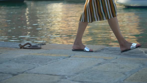 Close-up of a woman feet and legs walking in Portofino, Italy, a luxury resort town in Europe.