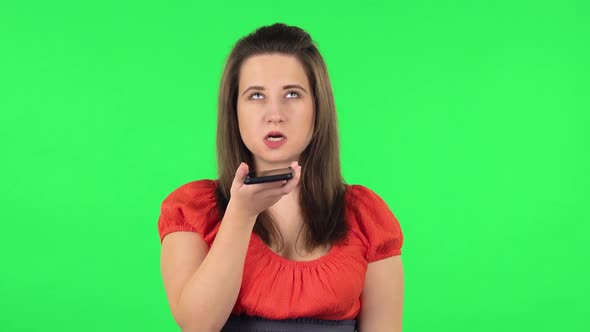 Portrait of Cute Girl Asking for Information on the Network Via Phone. Green Screen