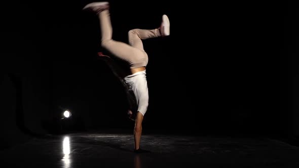 Young Man Dancing Breakdance in Black Studio