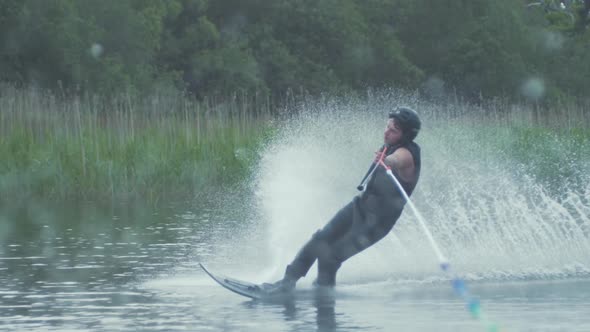 Young man low slalom waterski cut SLOW MOTION