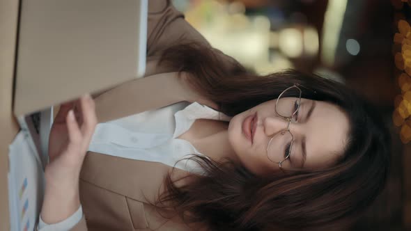 Woman Working on Laptop Whiel Sitting at Cafe Table