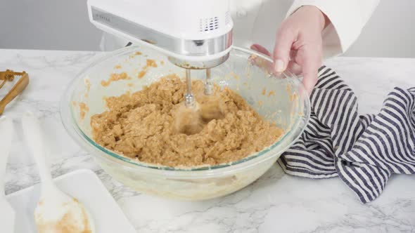 Step by step. Mixing ingredients in a glass bowl to make chocolate chip cookies.