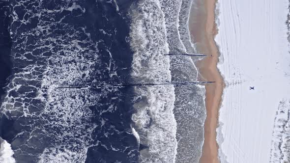 Snowy beach and waves, Baltic sea. Aerial view of winter