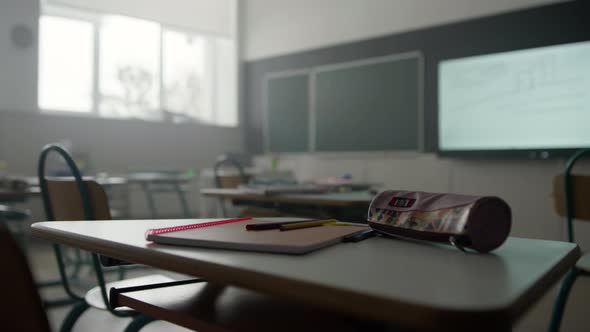 Notebook Pens and Pencil Case on Desk in Classroom