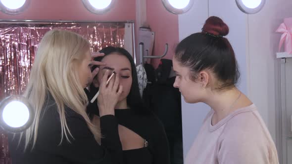 Girls Makeup Artists Makes Model Makeup in Beauty Studio