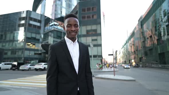 Portrait of smiling young black guy on the background of the business center