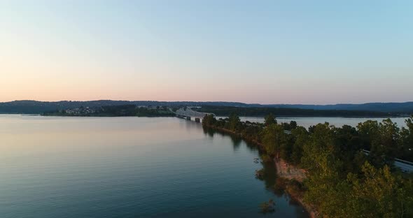 Aerial birds eye view over a lake in Missouri flying towards a bridge parallel with a highway