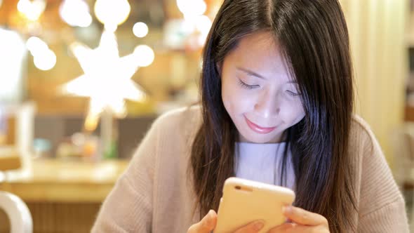 Woman working on mobile phone inside restaurant