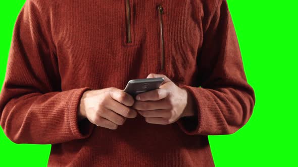 Caucasian man using a smartphone on green background