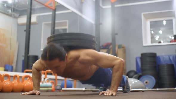 Man Does Pushups with Weight on His Back