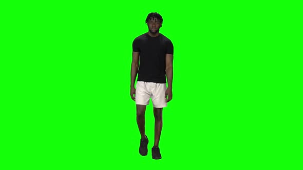 African American Man Is Walking at Green Screen, Chroma Key. Front View. Slow Motion