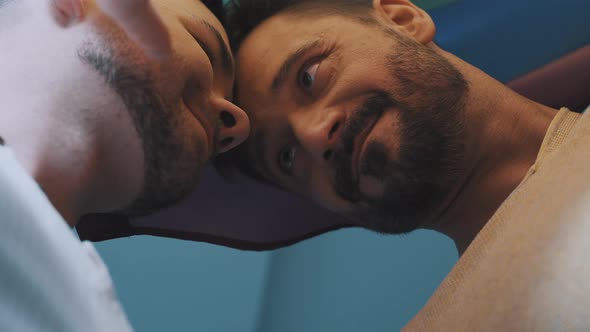 Close Up Homosexual Male Couple Dancing Head To Head Covered with Rainbow Flag
