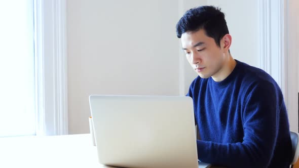 Man using laptop at home 4k