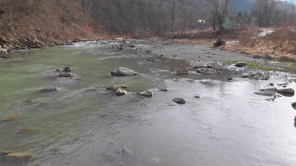 Flying Over Wild Mountain River Flowing with Stone Boulders and Rapids