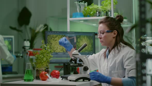 Biologist Scientist Looking at Test Sample Using Microscope