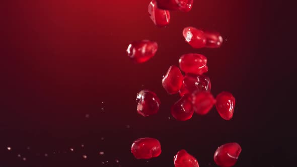 Pomegranate Grains Falling on Surface of Half Pomegranate in Slow Motion