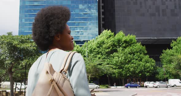 African american businesswoman walking and waving hand