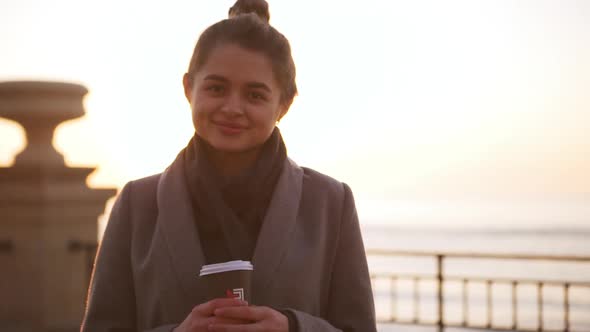 Portrait of Calm Caucasian Girl Standing Against Sea During Sunrise in Slowmotion