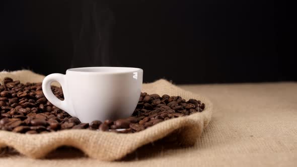 Coffee espresso on cup. Jute background and coffee beans