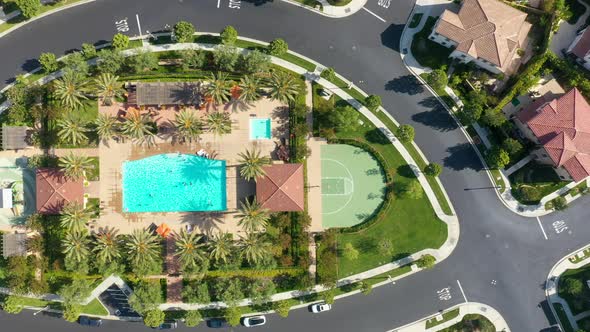 Aerial overhead shot of tropical Orchard Vista Park with palm trees and swimming pool during sunny d