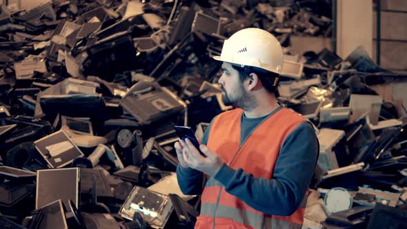 Male Specialist is Observing a Pile of Discarded Office Machines