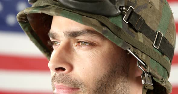 Soldier standing in front of American flag