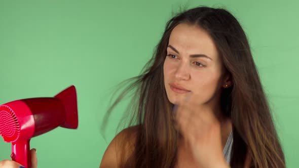 Young Woman Blow Drying Her Hair on Chromakey Background