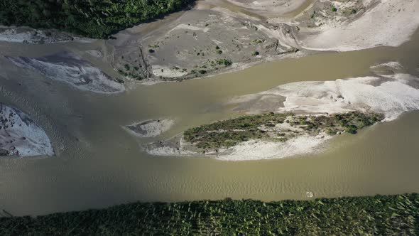 Aerial sliding over a dried river surrounded by spruce forest in Alaska in summer