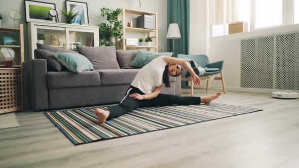 Slim Asian Girl Female Student Is Doing Yoga at Home Enjoying Stretching Exercises Sitting on Floor