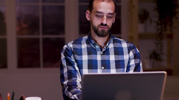 Tired Businessman Yawning While Working on His Laptop