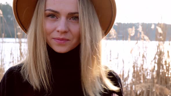 European Blonde Woman Smiling with Beige Hat in Black Sweater in the Countryside
