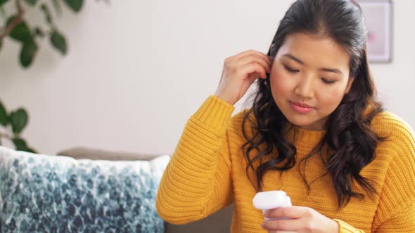 Asian Woman with Earphones and Smartphone at Home