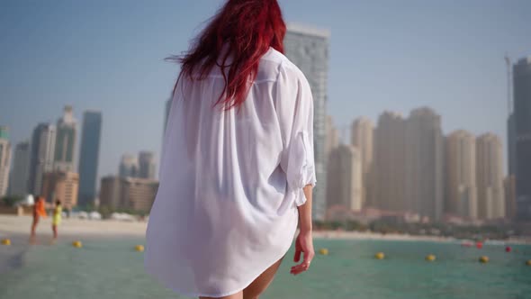 Woman in a White Shirt Walks Along the Beach of the Persian Gulf in Dubai