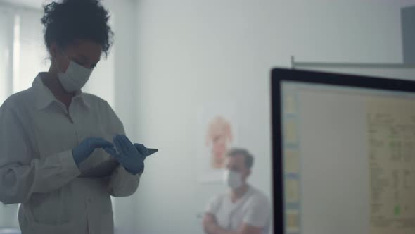 Woman Doctor Writing Tablet Computer Standing Office