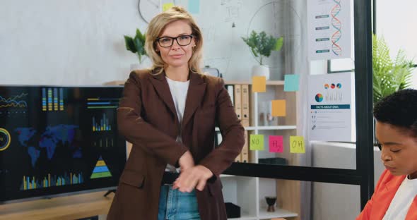 Businesswoman in Glasses Posing on Camera with Crossed Arms During meeting