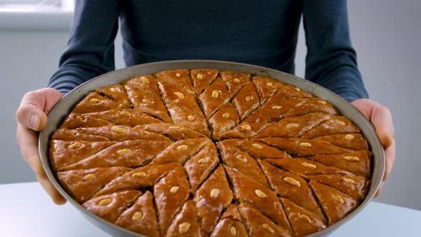 A Man is Holding Baklava