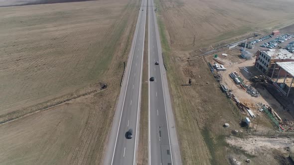 Flight Over the Highway Near the Field View of Road From Height Cars and Trucks Traffic on Highway