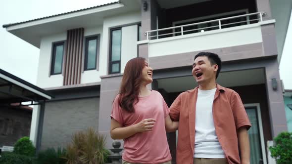 slow-motion of cheerful young couple standing outside their house