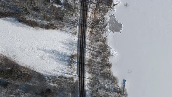 Road Along Shoreline Frozen Lake with Snow Aerial Top Down