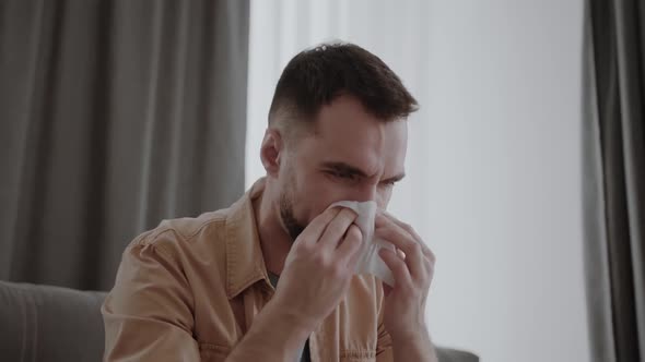 Runny Nose in a Man Holding Tissue Handkerchief Blowing Wiping His Running Nose